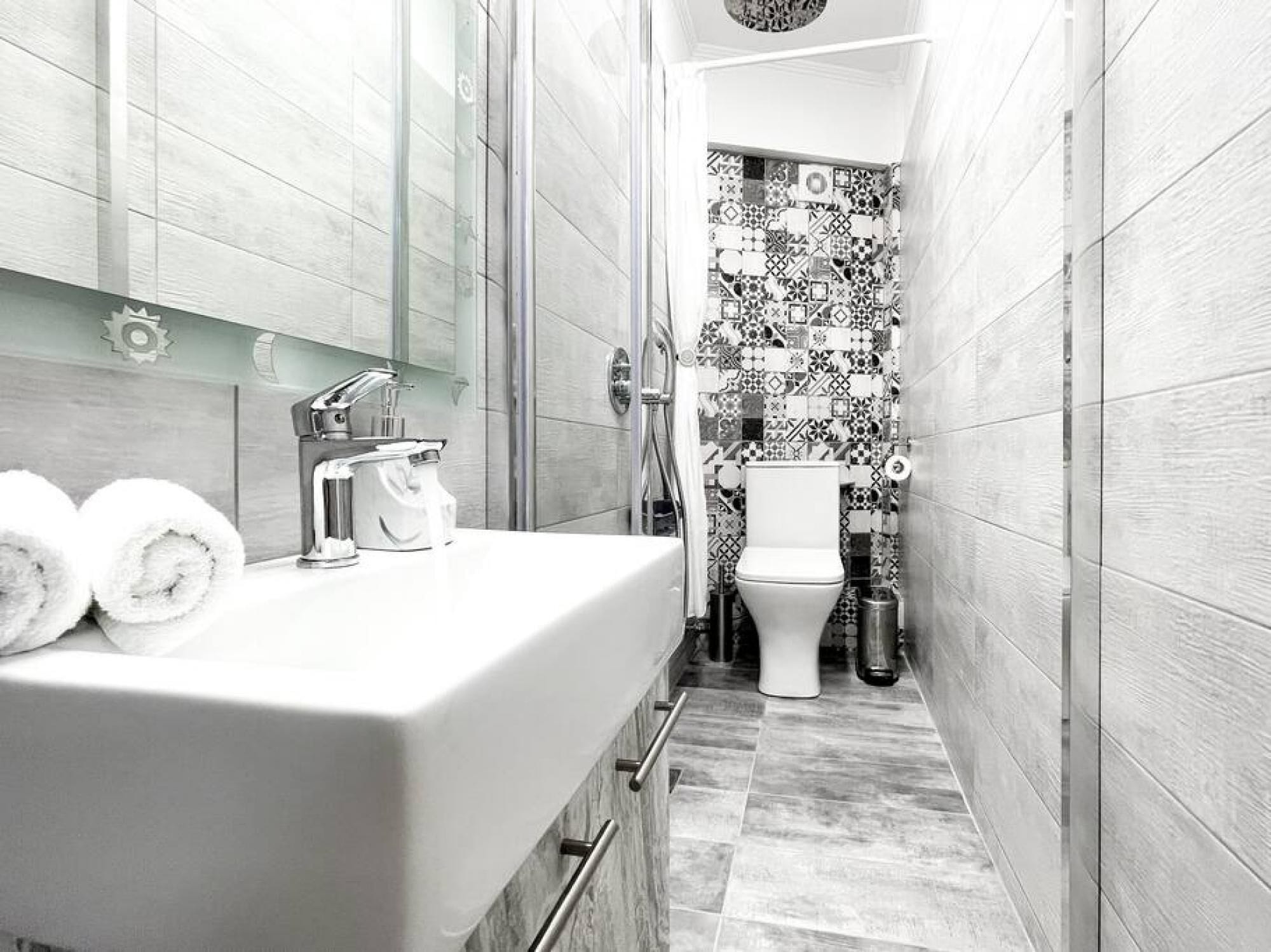 Une petite salle de bain avec un lavabo blanc, un miroir et des toilettes.
