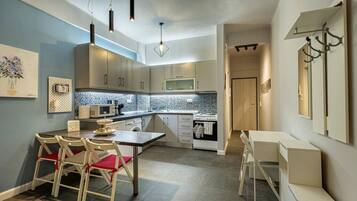 Cozinha moderna com área de refeições, destacando uma ilha central, luminárias pendentes e backsplash revestido de azulejos.