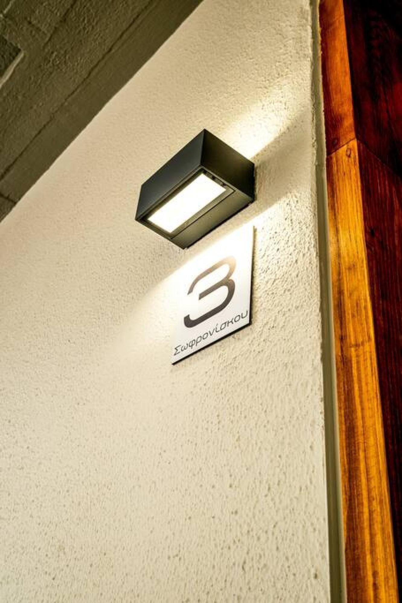 A wall-mounted light fixture and a number sign indicating room 3.