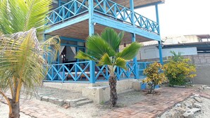 Un bâtiment à deux étages, doté de balustrades bleues et d’un patio couvert.