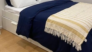 Una camera da letto con un letto, due cuscini, un comodino e una abat-jour.