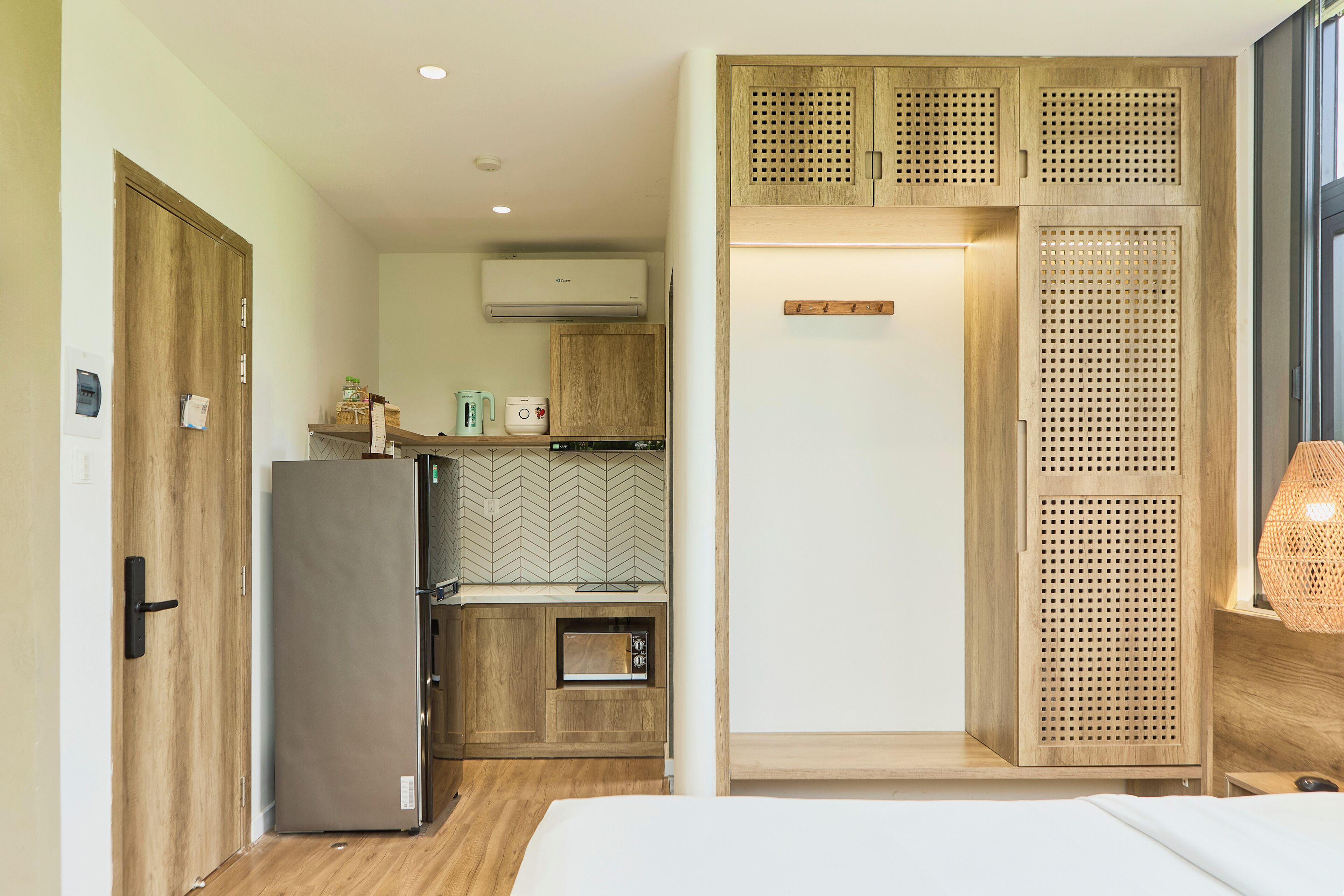 A compact kitchen with a refrigerator, oven, and wooden cabinets.