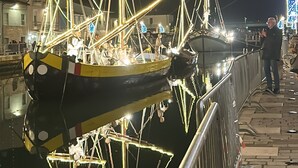 A nighttime scene with illuminated boats docked at a marina, reflecting on the water. - Hotel Perla (Cesenatico)