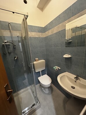 A bathroom with a glass shower enclosure, a toilet, and a sink. - Hotel Perla (Cesenatico)