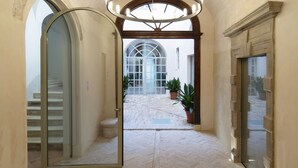 A corridor with a herringbone floor, arched doorways, and a central light fixture. - Palazzo Giusti Suites and Spa (Urbino)