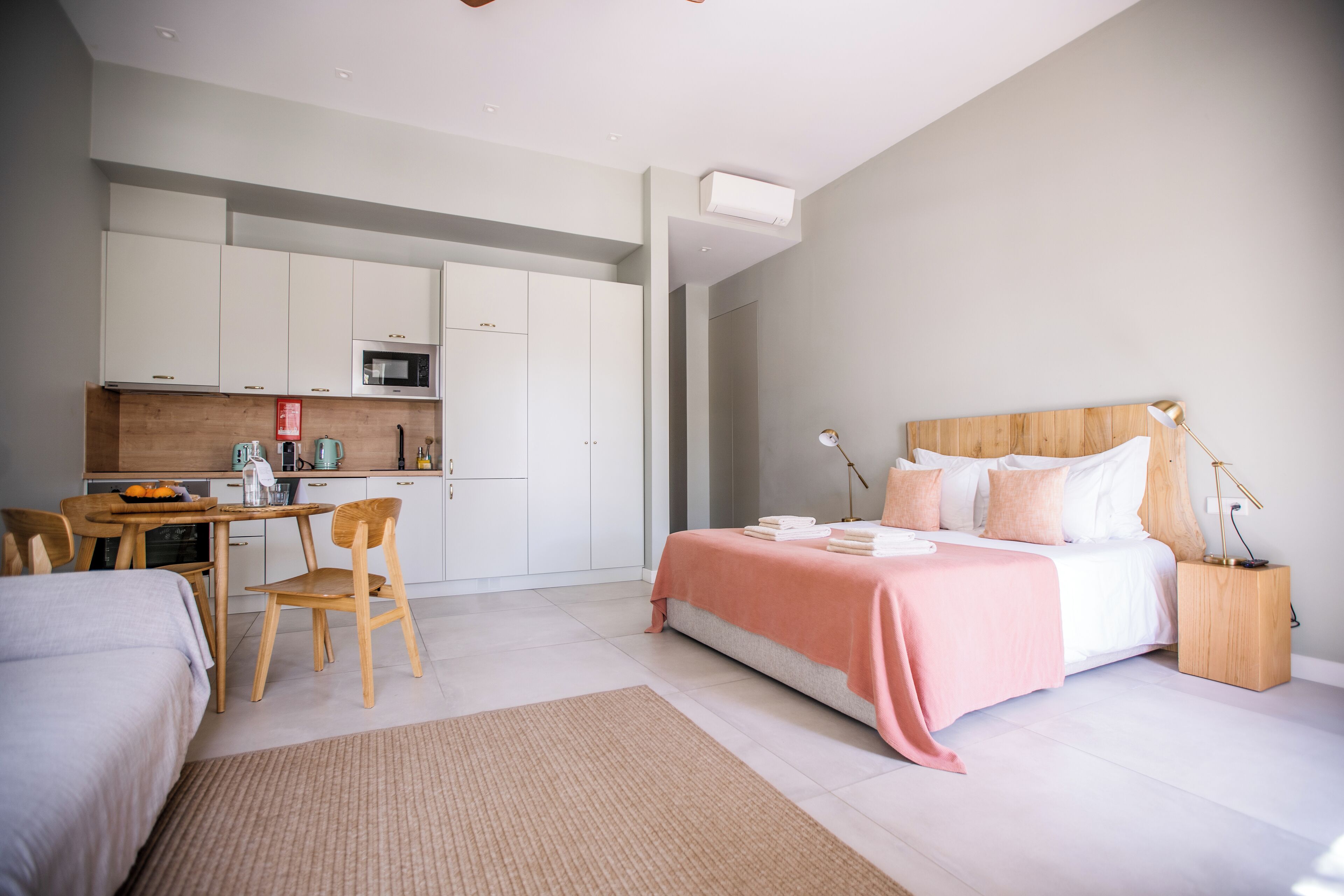 Une chambre moderne avec un grand lit, des tables de chevet et un coin bureau avec une chaise.