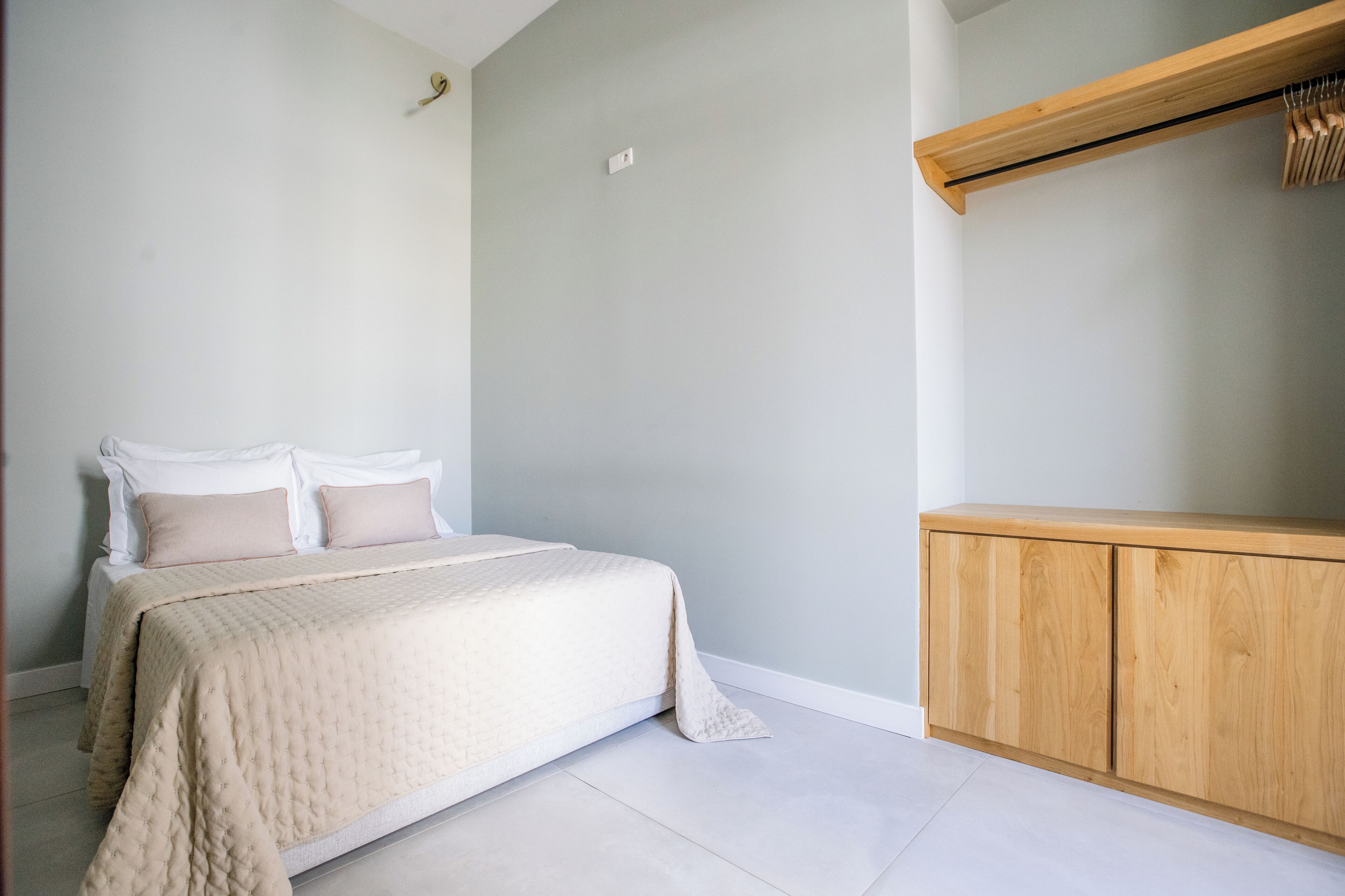 Ein Schlafzimmer mit einem Bett, einem Nachttisch und einer hellen Wand.