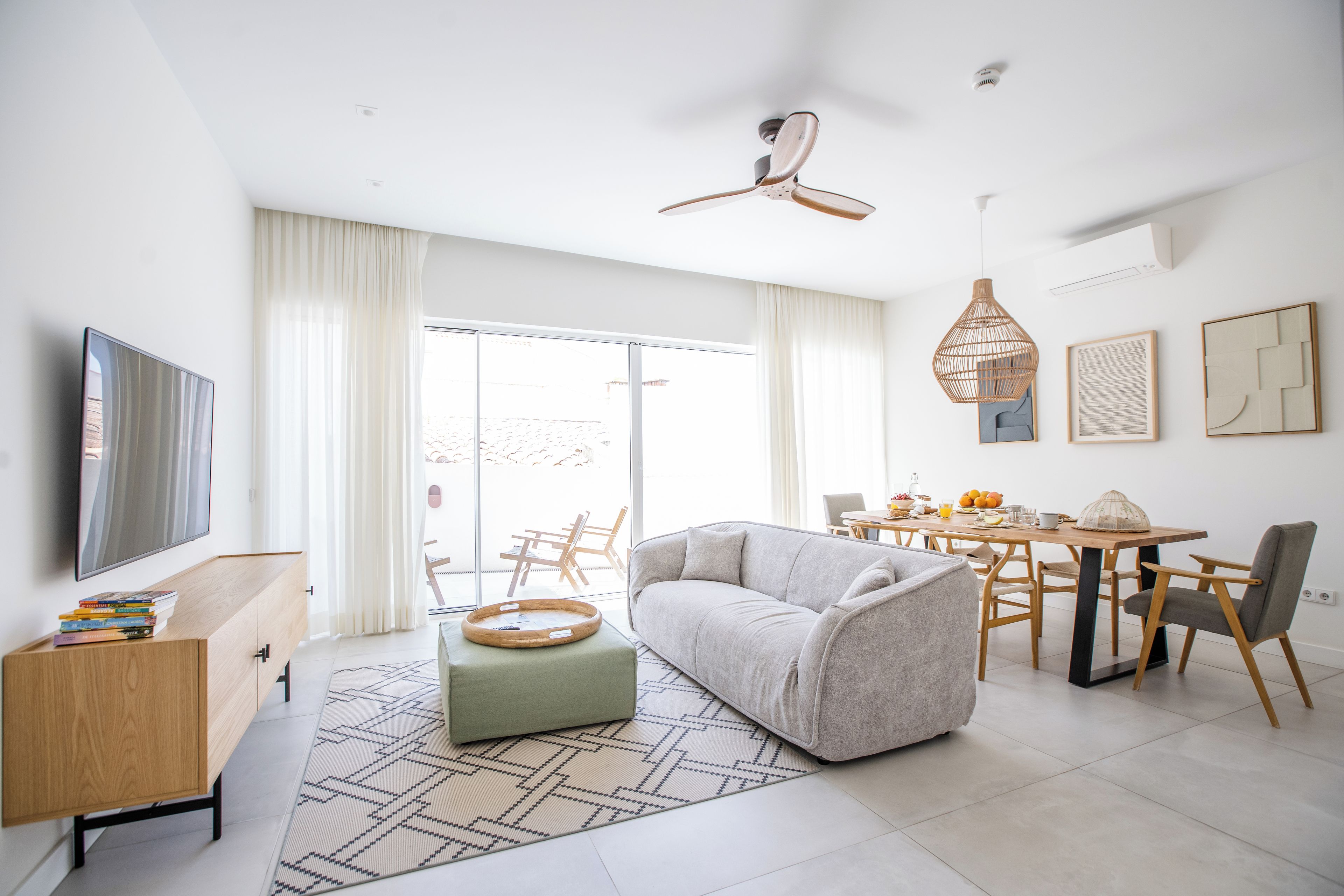 A modern living room with a sofa, a dining table, and a television.