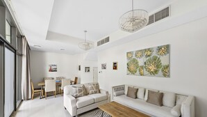 A modern living room with a sofa, coffee table, and artwork on the wall.