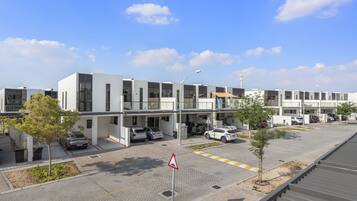 A modern building with multiple parking spaces and a pedestrian walkway.