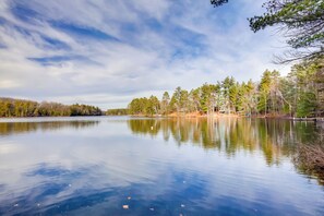 A calm lake with trees reflecting on the water, surrounded by a forest. - Lakefront Rhinelander Cabin w/ Dock & Fire Pit! (Rhinelander)