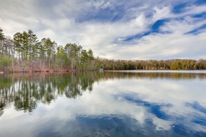 A calm lake with reflections of trees and a clear sky. - Lakefront Rhinelander Cabin w/ Dock & Fire Pit! (Rhinelander)