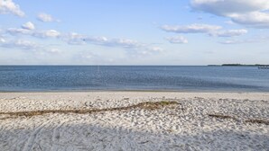 Una playa con cielo despejado y mar tranquilo.
