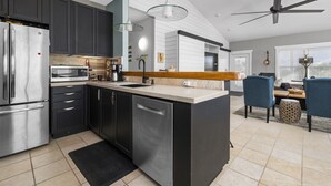 Una cocina moderna con gabinetes oscuros, electrodomésticos de acero inoxidable y una isla central.