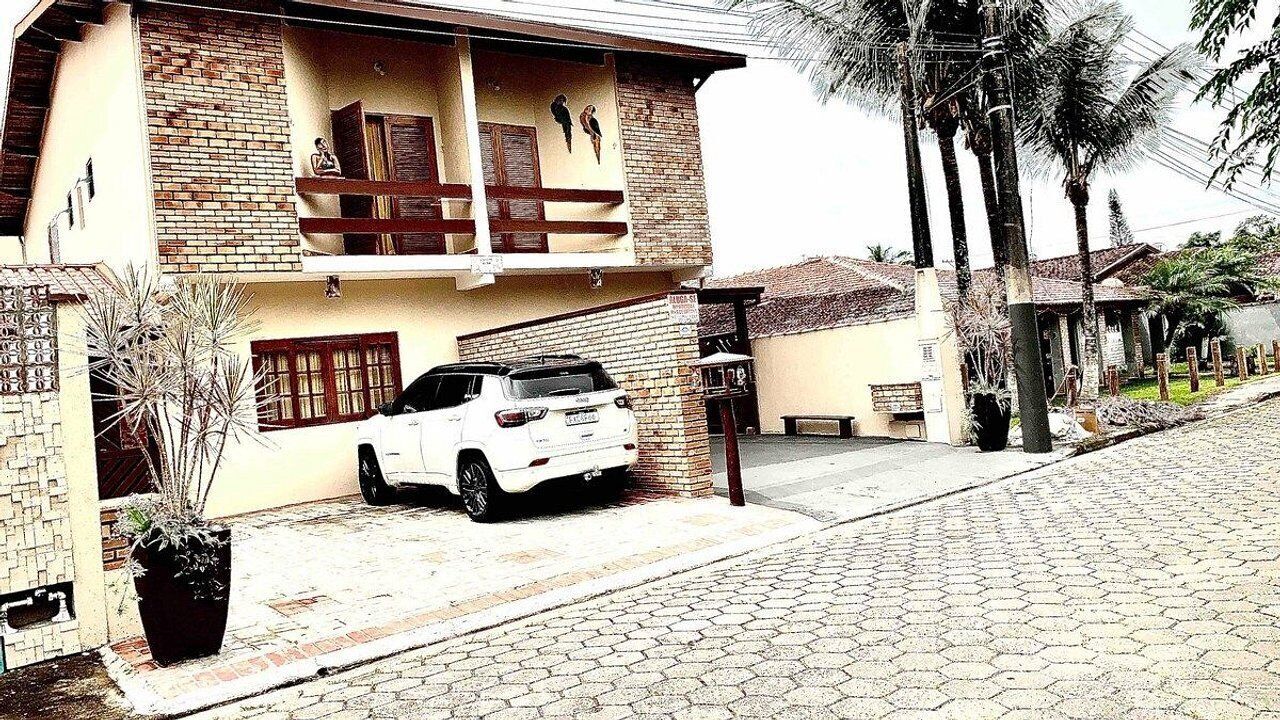 A two-story house with a white car parked in the driveway.
