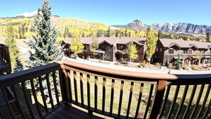 A wooden deck with a view of a row of cabins and a mountain range in the background. - Stunning Mountain Views! Fully Updated ! 2 miles from Purgatory Ski Resort (Durango)