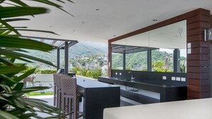 Een moderne keuken met een groot eiland, een inbouwspoelbak en uitzicht op een bergachtig landschap.
