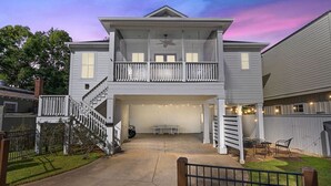 A two-story house with a covered garage, a balcony, and a staircase leading to the upper floor.