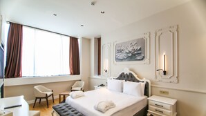 A hotel room with a large bed, a desk, a chair, a bench, and a bedside table. - S Class Hotel Convention Center (Gaziantep)