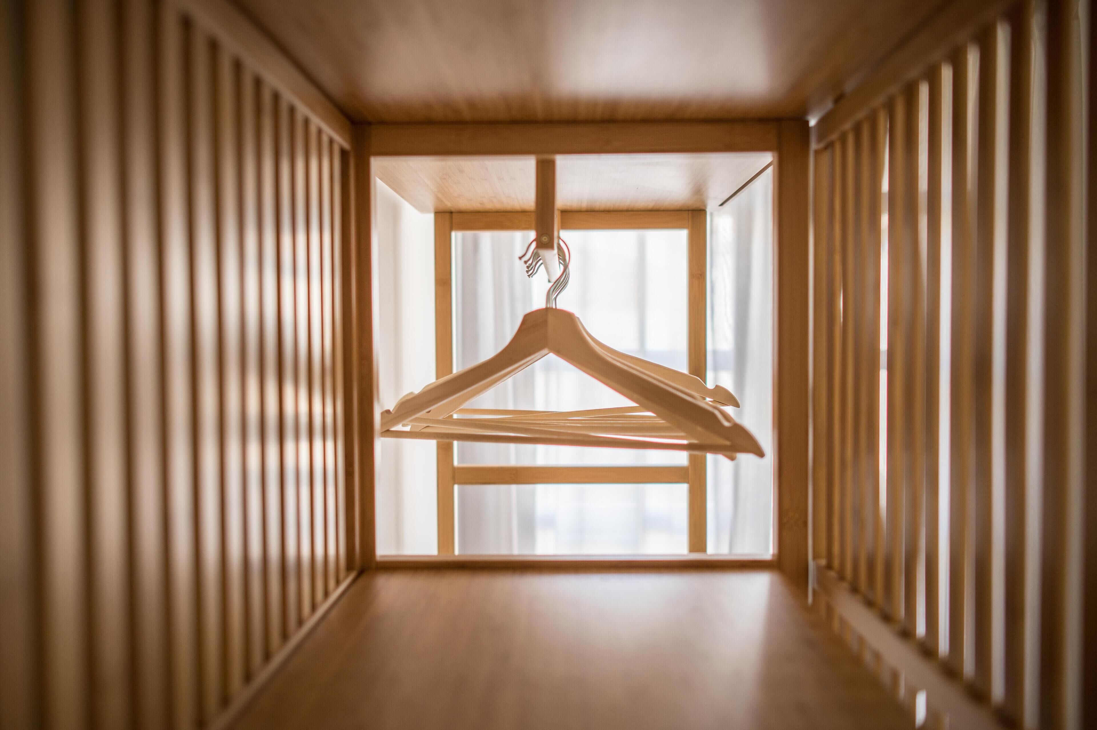 A hallway with wooden paneling and a wooden hanger in the center.