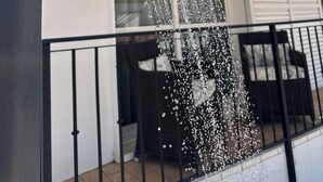 Un cabezal de ducha moderno al aire libre con agua corriendo.