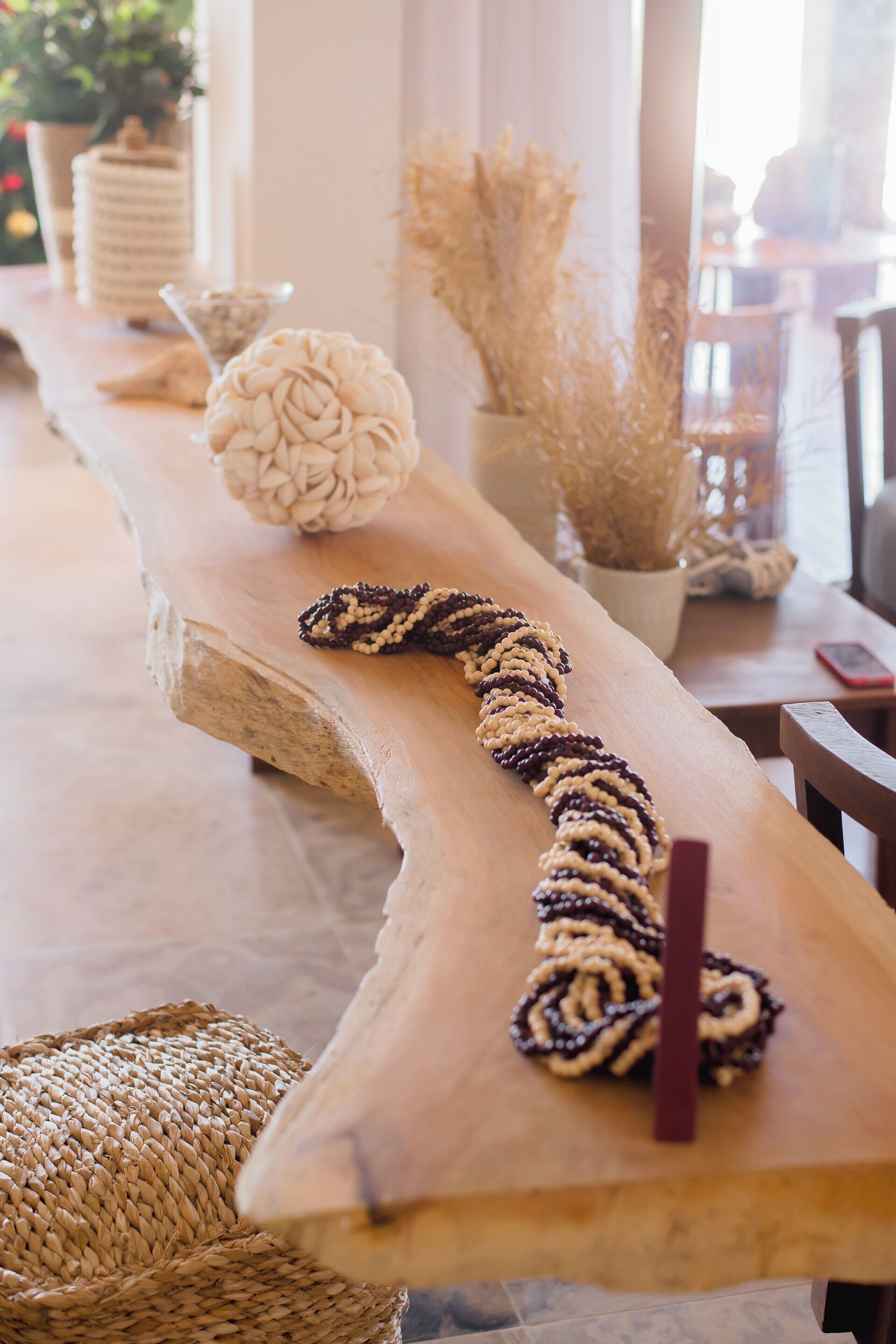 A wooden table with a braided item and a woven basket.