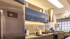 Une cuisine moderne dotée d’appareils électroménagers en acier inoxydable, d’un four encastré et d’un grand îlot central avec un évier.