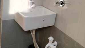 Un baño con lavamanos blanco, inodoro y ducha.