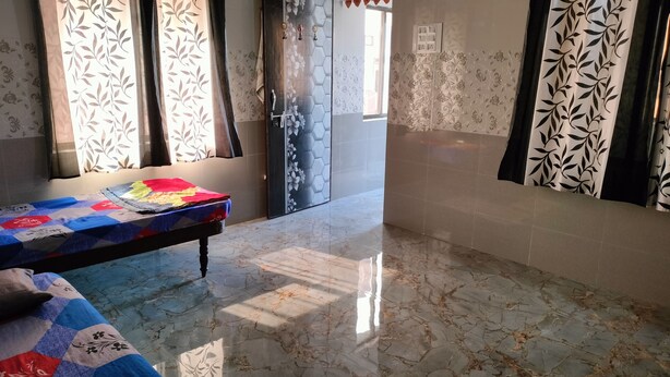 Una habitación con cama, un banco, una puerta con diseño floral y suelo de baldosas.