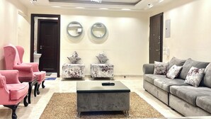 A modern living room with a grey sofa, pink armchairs, and a coffee table. - Block B - 401 (Agouza)