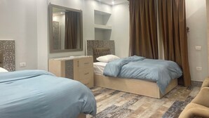 Un dormitorio con dos camas, un aparador, un espejo y una ventana con cortinas.