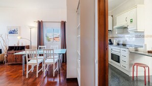 Un apartamento moderno con comedor, cocina y vistas a través de una ventana.