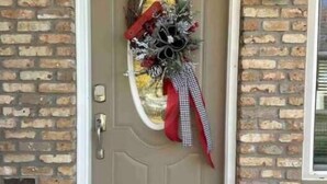 A brick wall with a door featuring a welcome mat and a wreath. - The Landing Zone.
 Comfortable and cozy three bedroom with two car garage.  (East Moline)