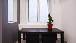 A dark wooden table with two benches, a potted plant, and a window with frosted glass. - Exclusive New Modern Apartment at Syntagma Square (Athens)