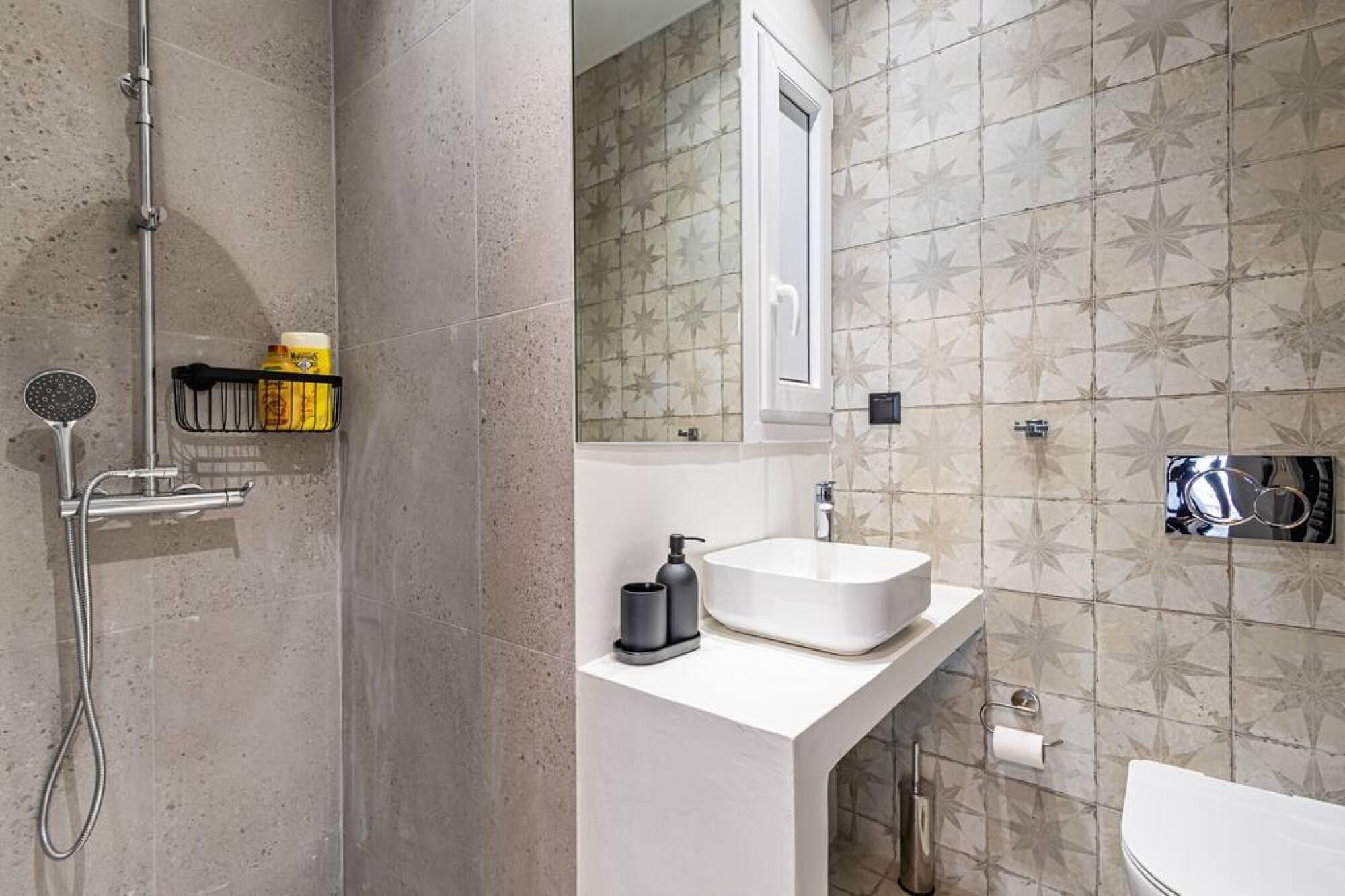 A bathroom with a shower, sink, and toilet.