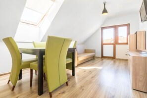 Ein Essbereich mit Tisch und Stühlen, einer Couch und einem Holzschrank.