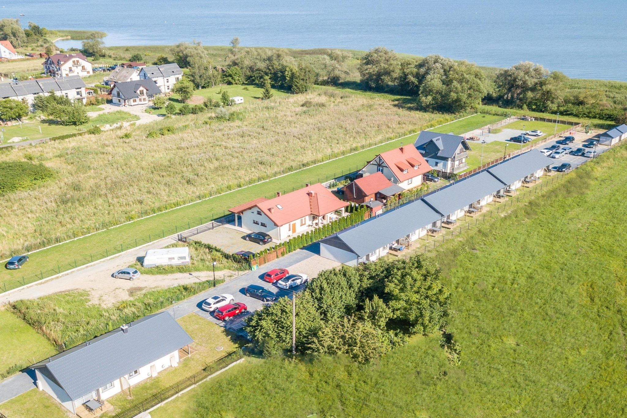 Asuinalue, jossa on taloja, parkkipaikka ja taustalla vesistö.