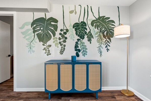 A room with a blue cabinet, a hanging plant wall, and a floor lamp. - Midtown 4 BR for Work Stays and Home Transition (Little Rock)