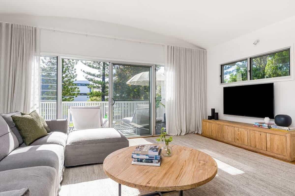 A modern living room with a sofa, a coffee table, and a TV.