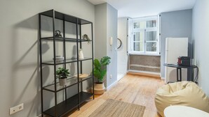 A modern apartment with a black shelving unit, a small dining area, and a window with a view. - GuestReady - Calming retreat in Miragaia (Porto)