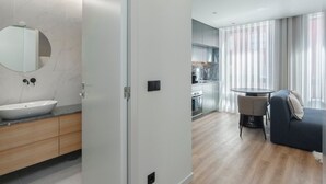 A modern bathroom with a marble sink, wooden cabinets, and a large mirror. - GuestReady - Trendy Studio Gaia (Vila Nova de Gaia)