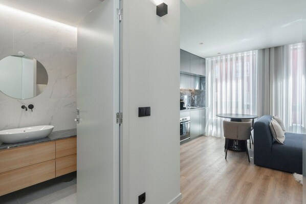 A modern bathroom with a marble sink, wooden cabinets, and a large mirror.