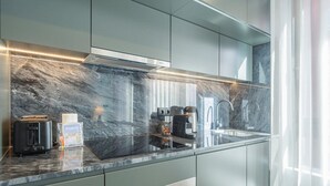 A modern kitchen with a marble countertop, stainless steel appliances, and a view of the city. - GuestReady - Trendy Studio Gaia (Vila Nova de Gaia)