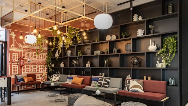 A modern living room with sofas, a coffee table, and shelves with decorative items. - MILESTONE Wroclaw Fabryczna by Tribera (Wroclaw)