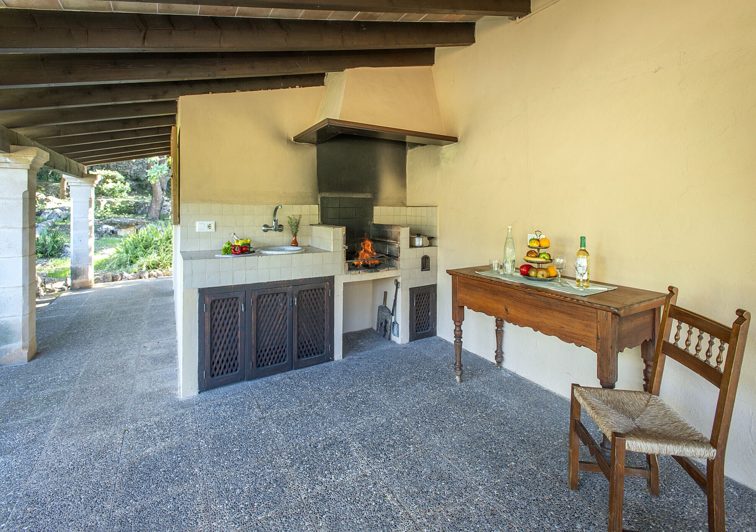 A kitchen with a tiled backsplash, a wooden table, and a chair.