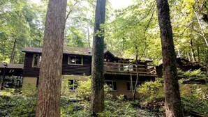 A cabin surrounded by tall trees in a forest.