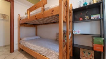 Un lit superposé avec une structure en bois, une étagère avec des boîtes de rangement et une étagère murale agrémentée d’objets décoratifs.