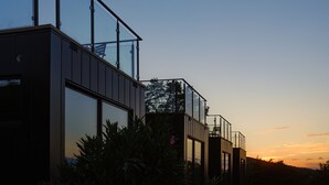 Un bâtiment moderne doté de grandes fenêtres en verre et d’un balcon.