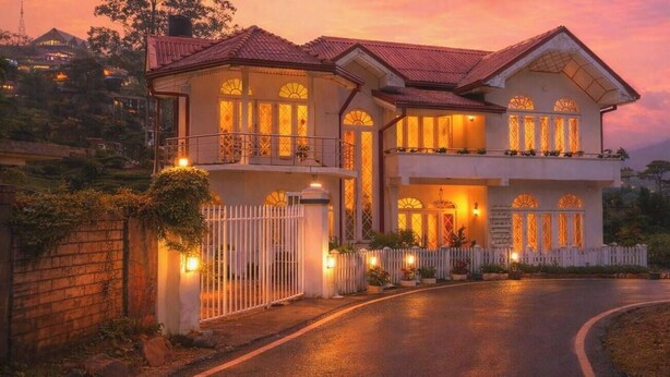 A two-story house with a balcony, a gated entrance, and a driveway. - MAPLES HOLIDAY RESORT (Nuwara Eliya)