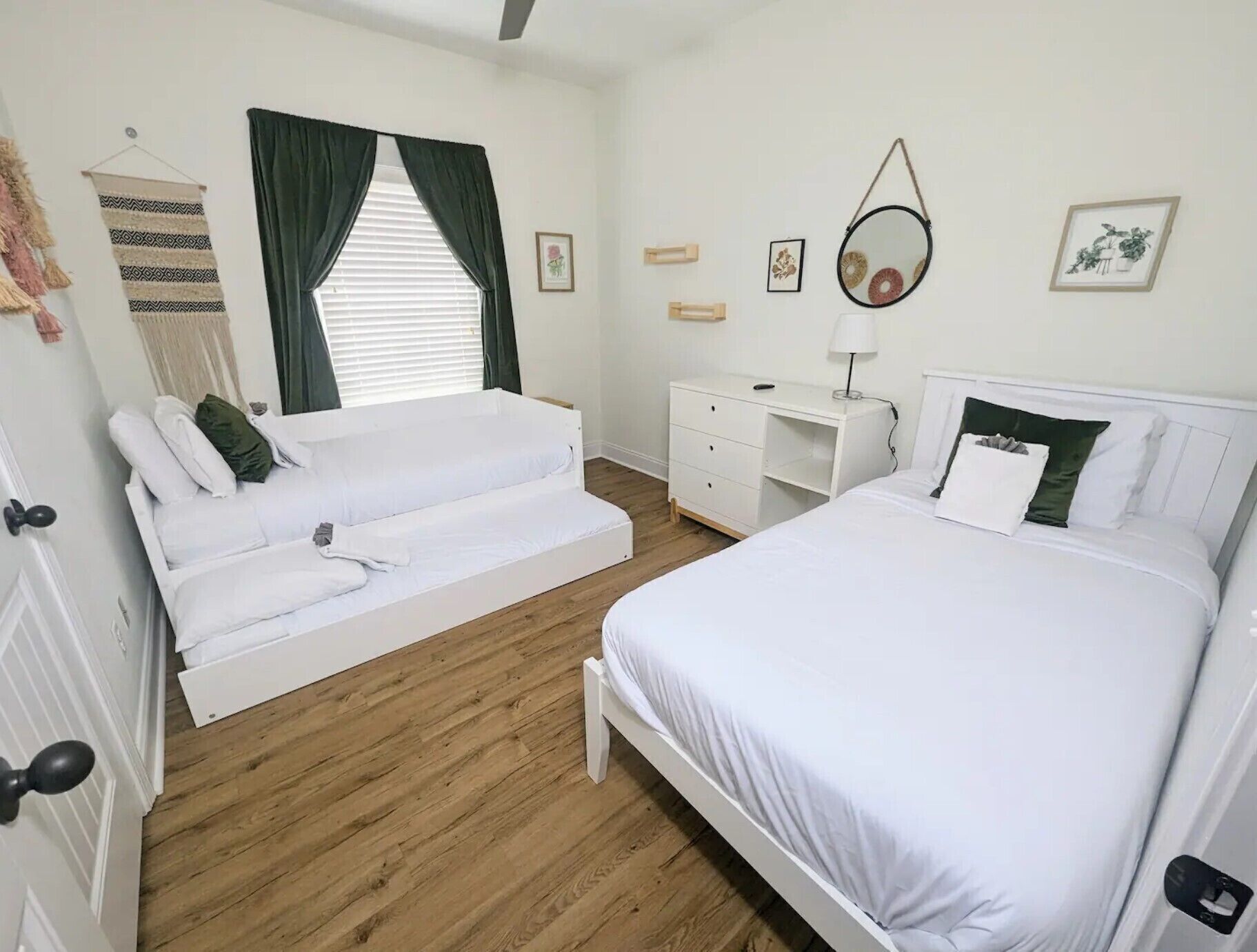 Een slaapkamer met een bed, een slaapbank, een bureau en een spiegel.